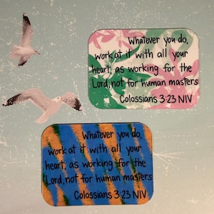 May include: Two decorative rectangular stickers with inspirational quotes. One sticker has a floral background, the other has a blue and orange striped design. Both stickers feature the text "Whatever you do, work at it with all your heart, as working for the Lord, not for human masters Colossians 3:23 NIV."