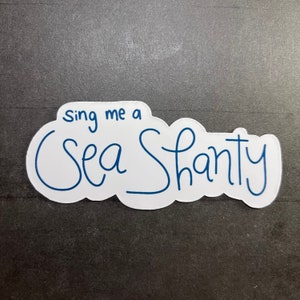 May include: White sticker with blue text that says "sing me a sea shanty".