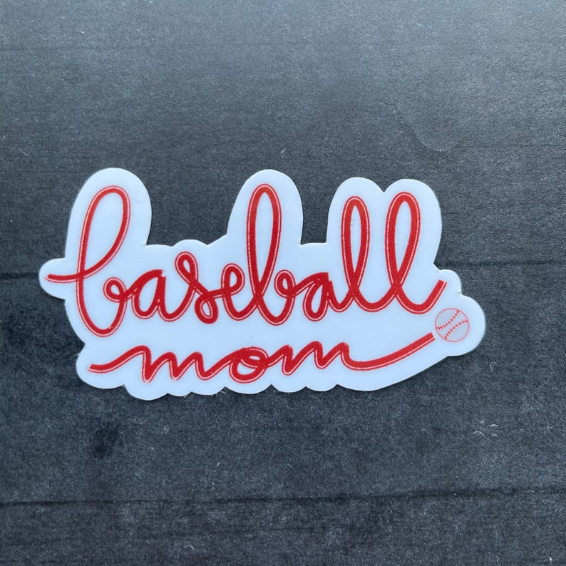 May include: White sticker with red cursive text that says "baseball mom" with a small red baseball graphic.