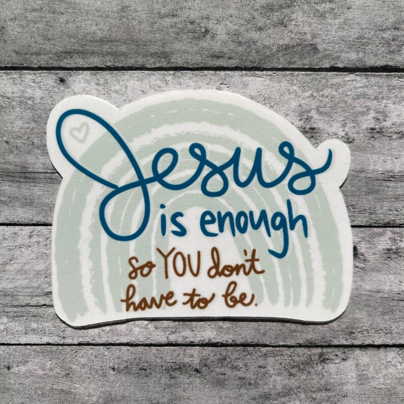 Puede incluir: Una pegatina blanca con un dise&ntilde;o azul y marr&oacute;n. La pegatina presenta un arco&iacute;ris con el texto "Jes&uacute;s es suficiente para que t&uacute; no tengas que serlo."