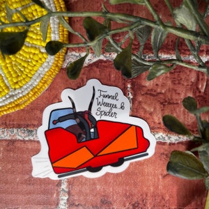 May include: A white sticker with a red and orange cartoon car with a spider inside. The text "Funnel Weeeee... & Spider" is written on the sticker.