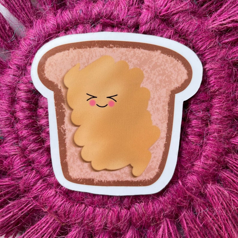 May include: A cartoon illustration of a slice of bread with peanut butter. The peanut butter has a smiling face with closed eyes and rosy cheeks. The bread is brown and the peanut butter is light brown.