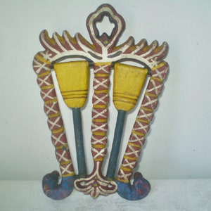 May include: A vintage, hand-painted wooden wall hanging featuring two yellow oars with blue handles. The decorative piece has a red, white, and yellow border and a star-shaped cutout at the top. The bottom has blue and red accents.