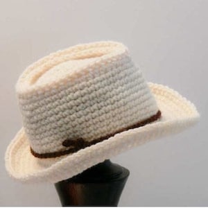 May include: A white crocheted cowboy hat with a brown leather band.
