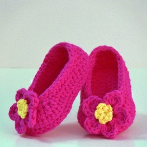 Peut inclure: Une paire de chaussons pour bébé en crochet rose avec des fleurs jaunes.