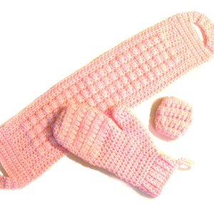 May include: A set of pink crocheted items including a long scarf, a mitten, and a small square. The items are made with a textured stitch.