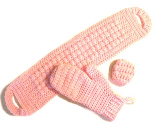 May include: A set of pink crocheted items including a long scarf, a mitten, and a small square. The items are made with a textured stitch.