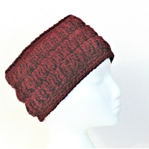 Puede incluir: Una diadema de punto color burdeos con un patrón texturizado. La diadema se muestra en una cabeza de maniquí blanca.