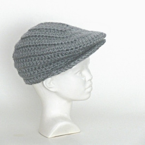 May include: A gray crocheted newsboy cap with a flat top and a brim.