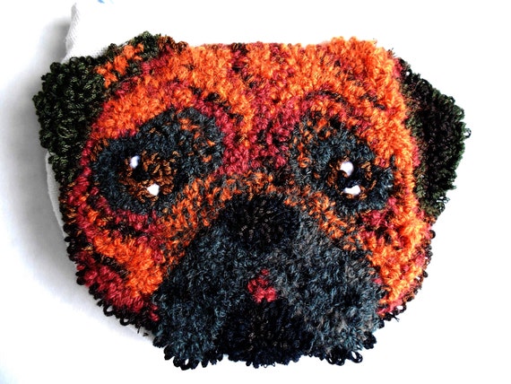 A punch-needle pug wristlet that's genuinely hand-crafted with a kawaii textile technique — small, tactile, and completely original.