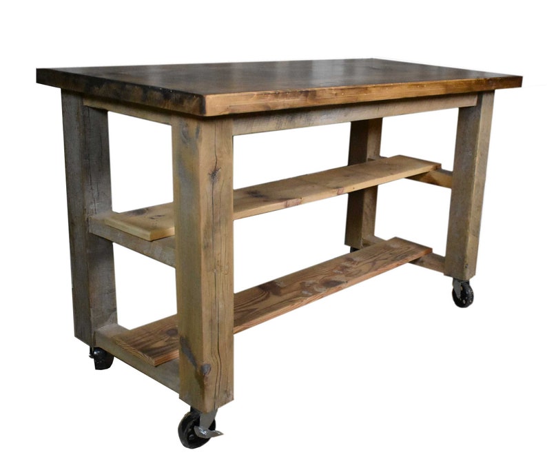May include: A rustic wooden kitchen island with two shelves and wheels. The island has a natural wood finish and is made of reclaimed wood.