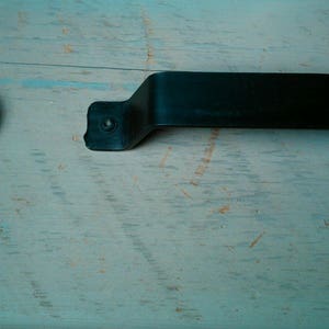 May include: A black metal door handle with a rounded knob on a light blue wooden surface.