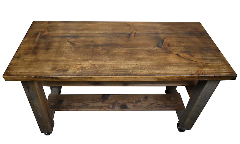 May include: A rustic wooden table with a distressed brown finish. The table has a single shelf and is supported by four legs. The table is on wheels.