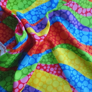 以下が含まれることがあります： カラフルな波状のストライプと水玉模様が繰り返される鮮やかな生地。赤、オレンジ、黄色、緑、青、紫など、さまざまな色があります。「S # H 3140 BY SILV」というテキストが白いタグに表示されています。