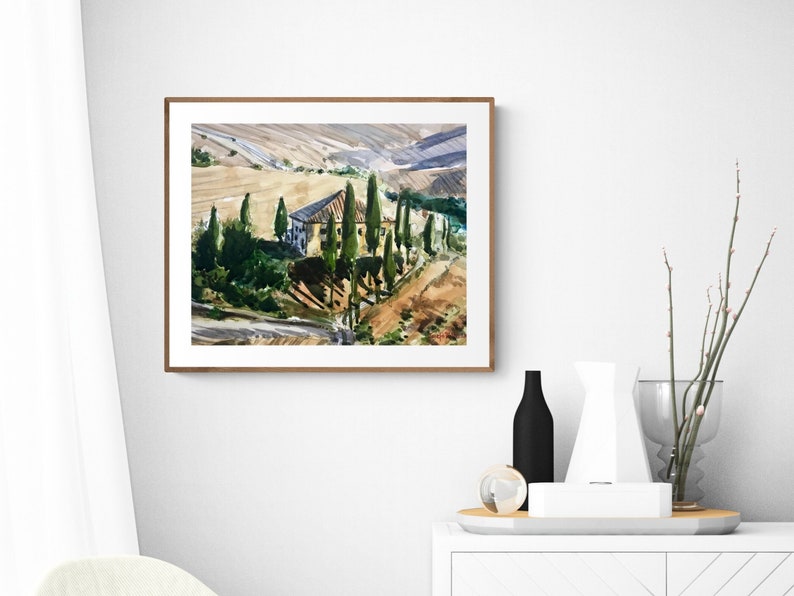 May include: A watercolor painting of a house with a brown roof and green trees in a landscape setting. The house is surrounded by trees and hills, and the sky is a light blue color.