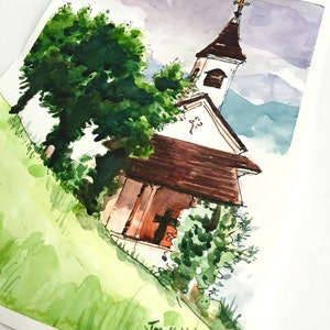 Puede incluir: Pintura acuarela de una peque&ntilde;a iglesia blanca con un techo marr&oacute;n y una cruz en la parte superior. La iglesia est&aacute; rodeada de &aacute;rboles y hierba verdes. El cielo es de color morado claro. La pintura est&aacute; firmada "Josef Deitke Nov 2015".