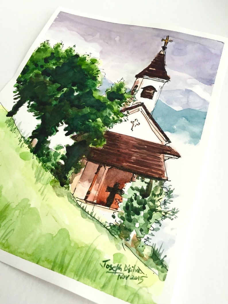 Puede incluir: Pintura acuarela de una peque&ntilde;a iglesia blanca con un techo marr&oacute;n y una cruz en la parte superior. La iglesia est&aacute; rodeada de &aacute;rboles y hierba verdes. El cielo es de color morado claro. La pintura est&aacute; firmada "Josef Deitke Nov 2015".
