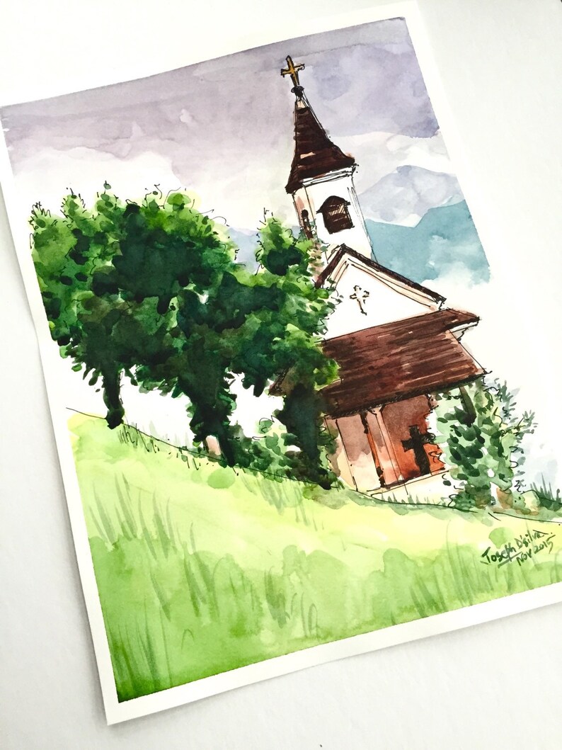 Puede incluir: Pintura acuarela de una peque&ntilde;a iglesia con un techo marr&oacute;n y un campanario blanco. La iglesia est&aacute; rodeada de &aacute;rboles y hierba verdes. El cielo es azul claro con algunas nubes. La pintura est&aacute; firmada "Tosch Brilha" y fechada "nov 2015".