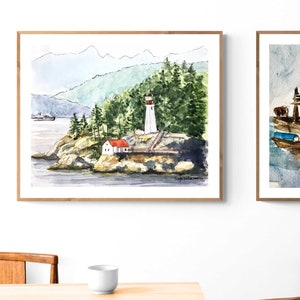 May include: Watercolor painting of a lighthouse on a rocky island with a red roofed house and green trees. The lighthouse is white with a red top and is surrounded by water. The painting is framed in a light wood frame.
