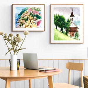 Puede incluir: Dos acuarelas enmarcadas. La primera pintura representa un pueblo italiano colorido en un acantilado con vistas al mar. La segunda pintura muestra una iglesia blanca con un techo marr&oacute;n en una colina verde.