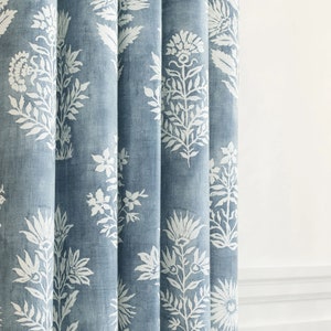 Elevate your windows with this indigo blue drapery features a large-scale floral  a watery blue ground cloth and off-white floral pattern