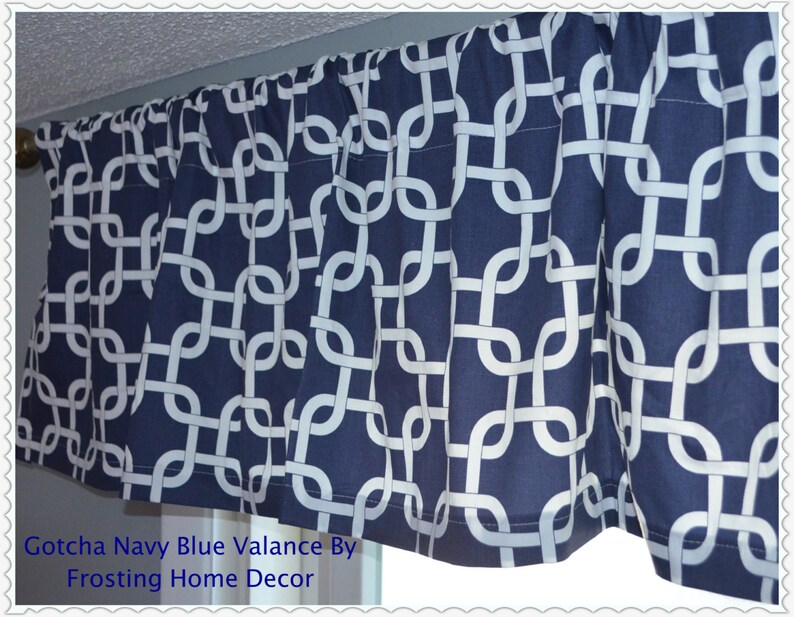 May include: Navy blue valance with a white geometric chain link pattern. The valance is pleated and hangs from a rod. The text "Gotcha Navy Blue Valance By Frosting Home Decor" is visible at the bottom.