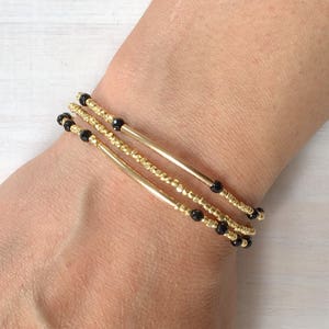 Black onyx faceted round bead and 14k gold round bead stretch bracelet
