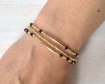 Black onyx faceted round bead and 14k gold round bead stretch bracelet