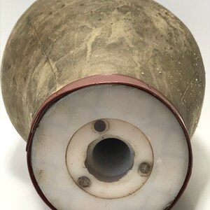 May include: A vintage, gray fabric mannequin head with a red plastic base. The base has a white plastic insert with a hole in the center.
