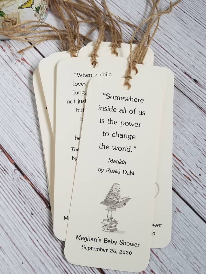 Pu&ograve; includere: Un set di segnalibri rettangolari in carta color crema con angoli arrotondati e cordini in spago marrone. Ogni segnalibro riporta la citazione "Somewhere inside all of us is the power to change the world." di Roald Dahl e un'illustrazione.