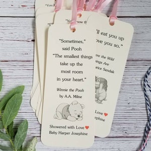Pu&ograve; includere: Un set di segnalibri rettangolari in carta color crema, ciascuno dotato di un foro nella parte superiore con un nastro rosa chiaro. I segnalibri presentano citazioni letterarie stampate, illustrazioni di personaggi e testo personalizzato.