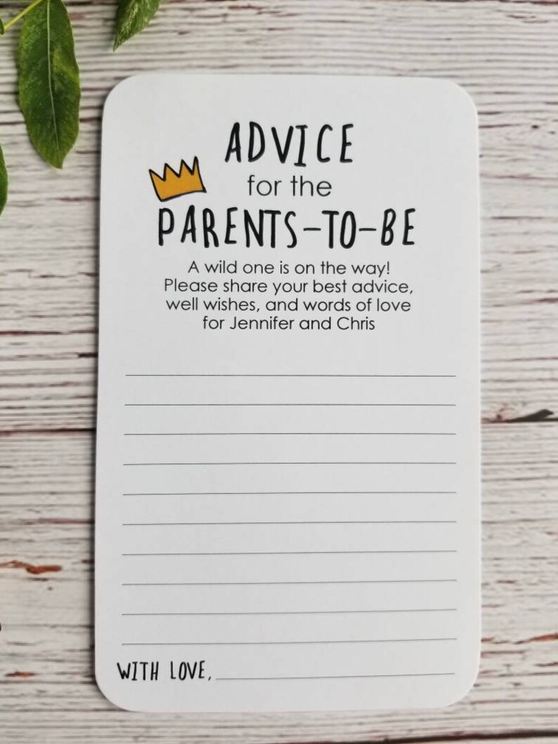 May include: A white card with black text that reads "Advice for the Parents-to-Be". A yellow crown is above the text. The card has lined paper for writing advice for the parents-to-be. The text at the bottom of the card reads "With Love."