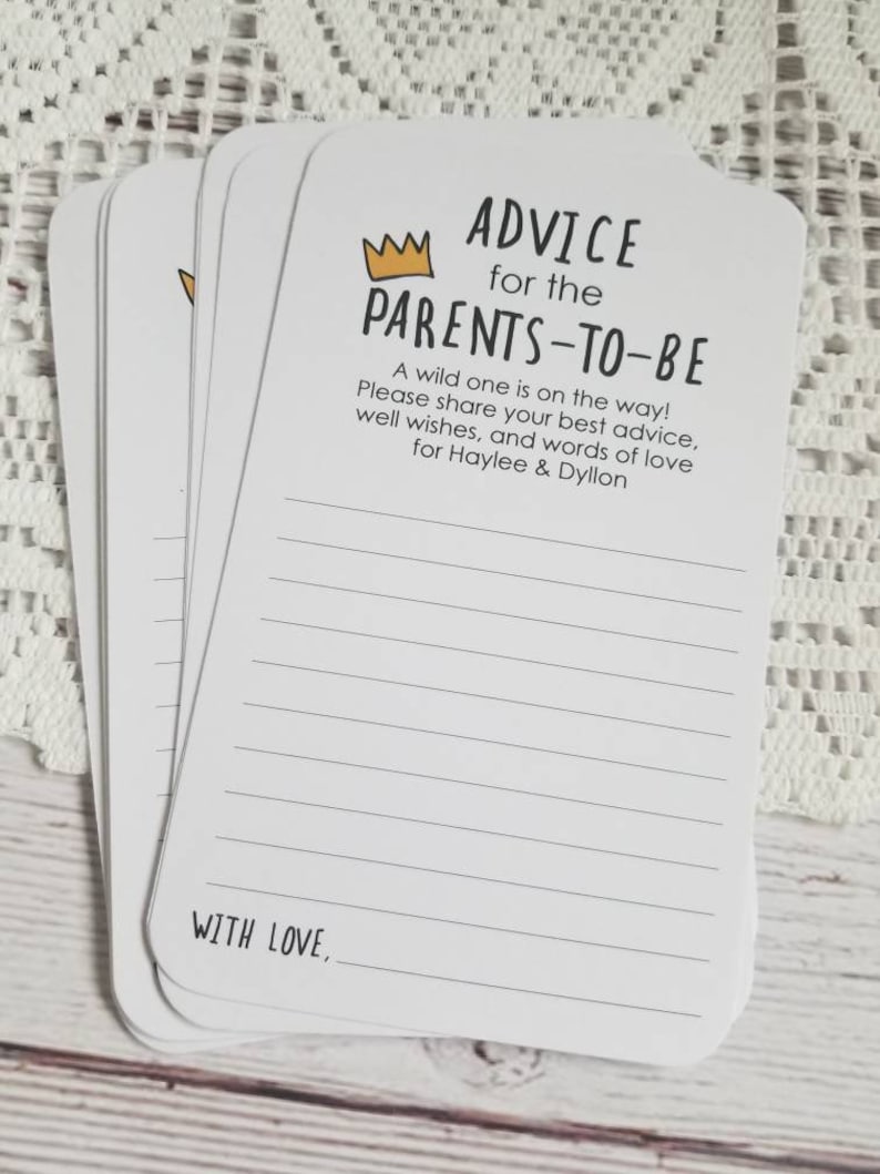 May include: A stack of white cards with black lines and the text "ADVICE for the PARENTS-TO-BE" with a gold crown above the text. The text continues with "A wild one is on the way! Please share your best advice, well wishes, and words of love for Haylee & Dyllon." The bottom of the card says "WITH LOVE,".