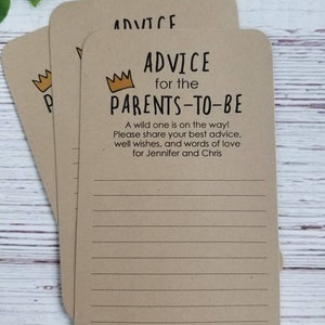 May include: Three brown cards with lined paper and a gold crown graphic. The text on the card reads "Advice for the Parents-to-Be". A wild one is on the way! Please share your best advice, well wishes, and words of love for Jennifer and Chris. With love."