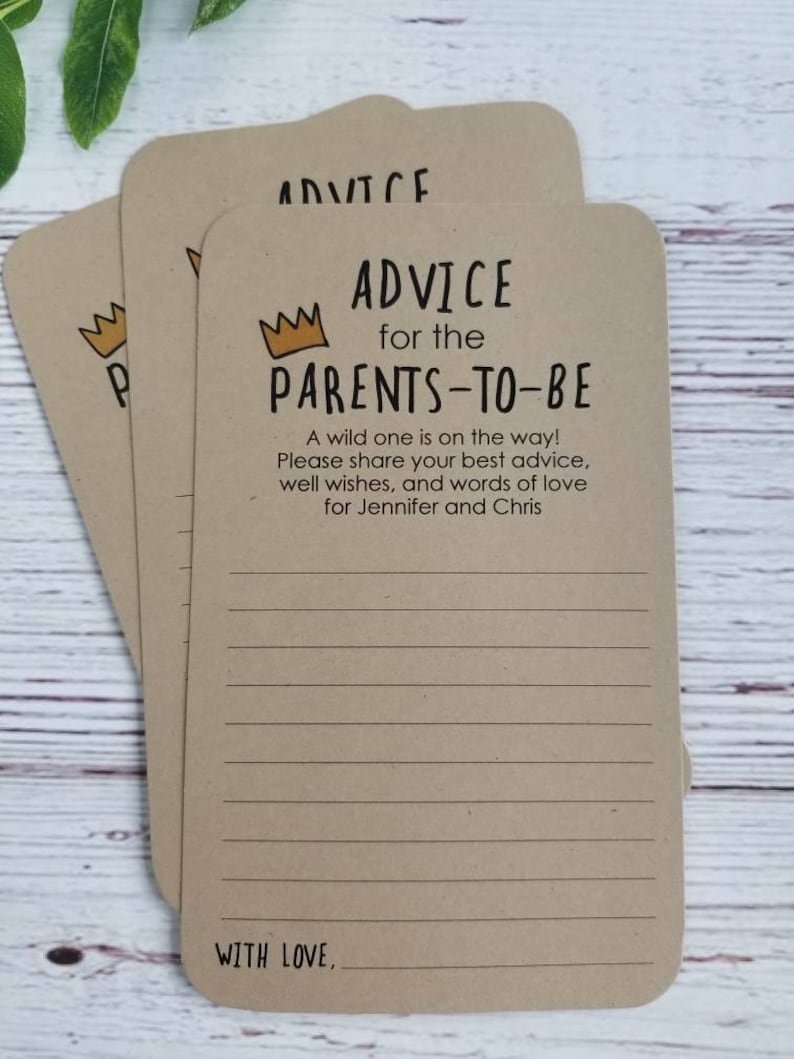 May include: Three brown cards with lined paper and a gold crown graphic. The text on the card reads "Advice for the Parents-to-Be". A wild one is on the way! Please share your best advice, well wishes, and words of love for Jennifer and Chris. With love."