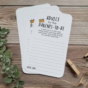 May include: A set of white cards with black and gold text. The cards feature a crown icon and the text "Advice for the Parents-to-Be". The text continues with "A wild one is on the way! Please share your best advice, well wishes, and words of love for Jennifer and Chris". The cards have lines for writing and the text "With Love."