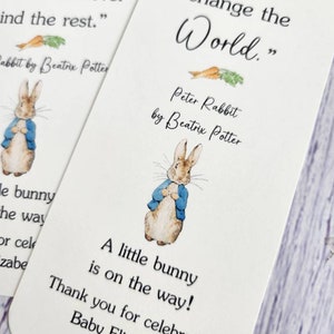 May include: A white card with a Peter Rabbit illustration and the quote "The smallest one can change the world."  The card also includes the text "Peter Rabbit by Beatrix Potter" and "A little bunny is on the way! Thank you for celebrating Baby Elizabeth!"