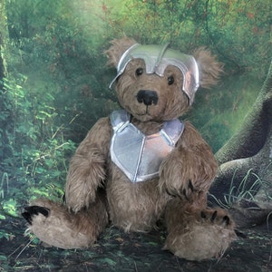 Op de afbeelding: Een bruine teddybeer met een zilveren helm en harnas, zittend in een groene bosomgeving.