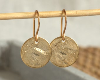 Shiny small gold earrings with an irregularly structured surface