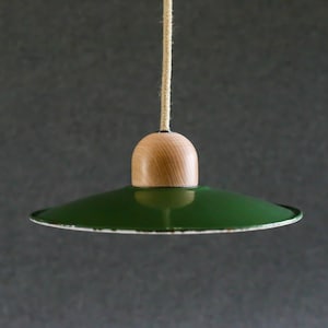 Może przedstawiać: Zielona lampa wisząca z drewnianym baldachimem. Lampa jest zawieszona na suficie za pomocą sznurka.