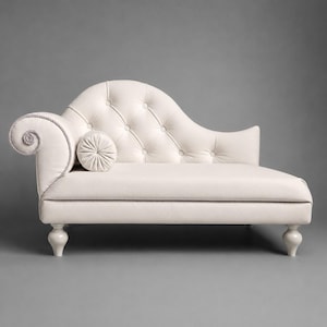 May include: An off-white chaise longue featuring a tufted backrest with button detailing, a curved armrest with rope trim, and a matching cylindrical bolster cushion. The piece is supported by four light-coloured, turned wooden legs.