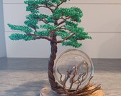 Green and brown wire tree on wood slice without pictured globe.