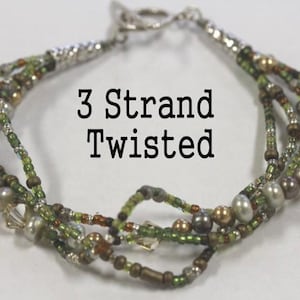 May include: A three-strand twisted bracelet with a silver clasp. The bracelet features a mix of green, brown, and pearl-coloured beads. The text "3 Strand Twisted" is displayed on the image.