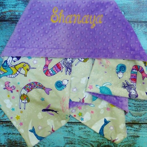 May include: A purple hooded baby blanket with a mermaid and seahorse design. The blanket is personalised with the name "Shanaya".
