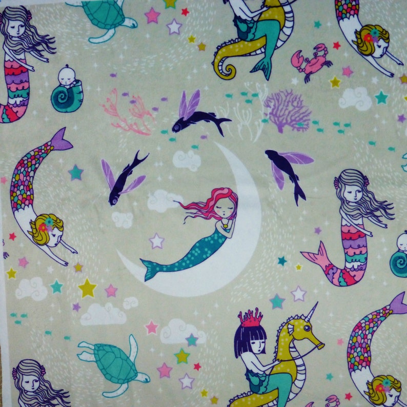 May include: A beige fabric with a repeating pattern of mermaids, seahorses, fish, stars, and clouds. The mermaids are in various poses, some are swimming, some are sleeping, and some are riding seahorses. The fabric is ideal for crafting projects, such as making cushions, blankets, or tote bags.