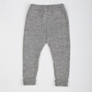 May include: Gray knitted baby leggings with a ribbed texture.