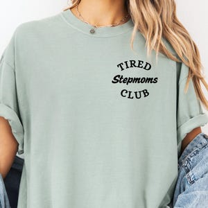 May include: A light green t-shirt with the text "TIRED Stepmoms CLUB" in black lettering.