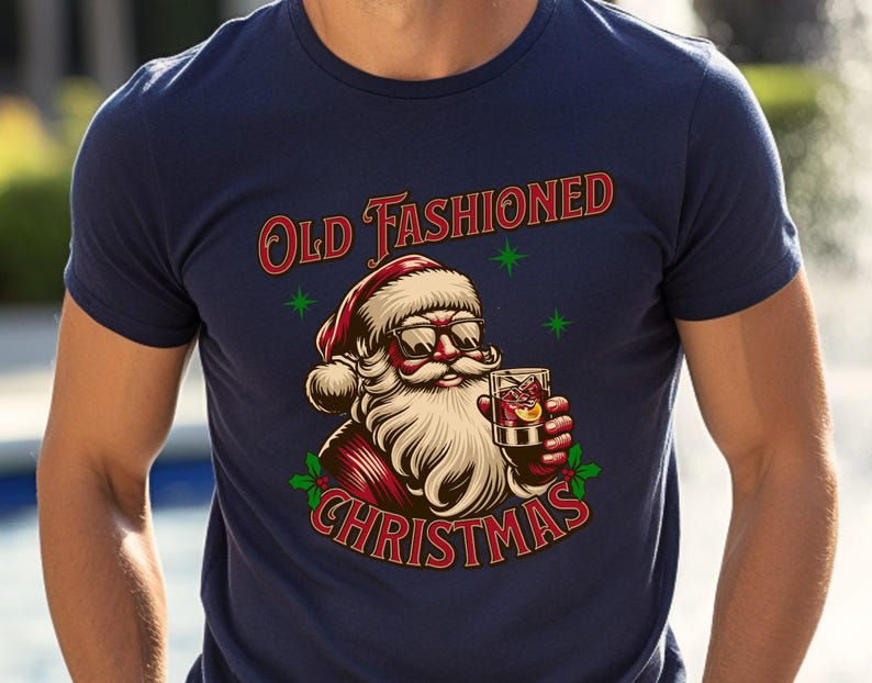 K&ouml;nnte beinhalten: Marineblaues T-Shirt mit einer Grafik von Santa Claus mit Sonnenbrille und einem Cocktail. Der Text "Old Fashioned Christmas" ist in Rot und Gr&uuml;n &uuml;ber der Santa-Illustration abgebildet.