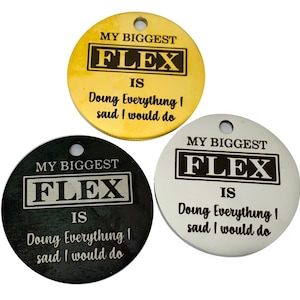 May include: Three round metal tags with the text "My Biggest Flex Is Doing Everything I Said I Would Do" in black lettering on a gold, silver, and black background.