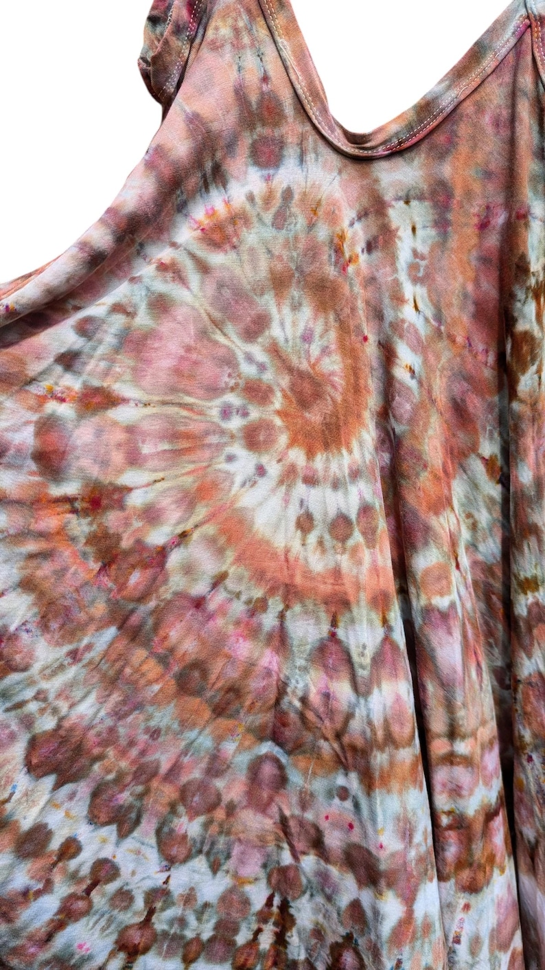 Op de afbeelding: Een mouwloos hemdje met een spiraalvormig tie-dye patroon in tinten terracotta, oudroze, gedempt bruin en cr&egrave;me. Het kledingstuk heeft een ronde halslijn en een los, vloeiend silhouet met zichtbare stiksels langs de rand van de kraag.